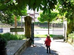 Entrada principal del parque con niño caminando hacia el interior
