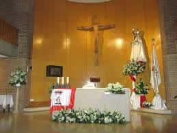 Interior del altar mayor de la iglesia decorado con flores y crucifijo