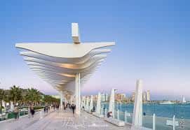 Estructura arquitectónica icónica del Palmeral de las Sorpresas frente al mar al atardecer