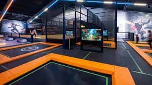 Interior del parque con trampolines y pantallas interactivas
