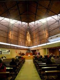 Vista frontal del interior de la iglesia con el altar y la congregación sentada