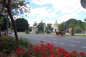 Vista panorámica de la Avenida del Cid con carril central, jardines floridos y carruaje tirado por caballos