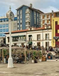 Plaza de la Cuesta del Cholo con el reloj histórico y terrazas llenas de personas