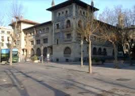 Fachada del edificio histórico de la Plaza de Bilbao con árboles y autobús en primer plano