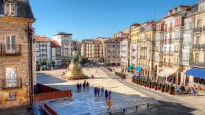 Vista panorámica de la Plaza de Bilbao en Vitoria-Gasteiz con edificios históricos y gente caminando
