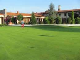 Jugador en el green frente al club house del campo de golf La Llorea