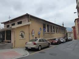 Fachada principal de la iglesia con coches aparcados frente a ella