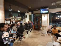 Ambiente interior del Bar Malavida con clientes sentados, barra y televisión encendida