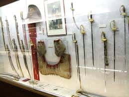 Exposición de espadas históricas y armamento en vitrina del museo