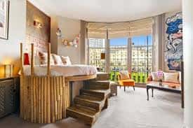 Habitación con estilo rústico y moderno, cama elevada de madera y gran ventana con vistas a la ciudad