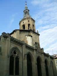 Vista exterior de la Iglesia de San Pedro Apóstol en Vitoria, destacando su torre campanario y fachada gótica bajo cielo azul