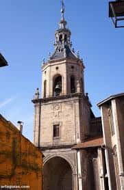 Detalle de la torre campanario de la iglesia con cielo despejado y elementos arquitectónicos barrocos visibles