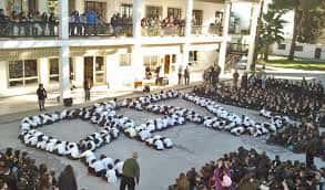 Alumnos formando figuras en el patio durante un evento escolar