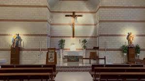 Interior de la Parroquia de la Virgen del Camino y San Andrés con altar principal y crucifijo central