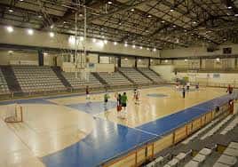 Vista general del interior del pabellón deportivo con gradas y cancha de baloncesto