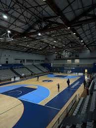 Interior del polideportivo mostrando la estructura del techo y la pista de juego