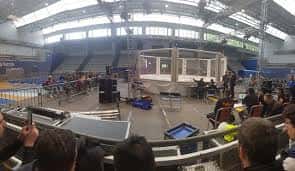 Escenario montado dentro del pabellón para un evento con público sentado