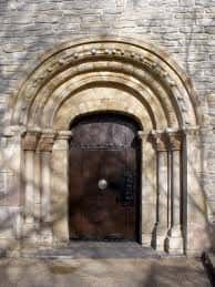 Puerta principal de la Ermita del Santo Cristo de Abetxuko con arco románico y detalles en piedra