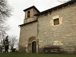 Lateral de la Ermita del Santo Cristo de Abetxuko con banco y árboles desnudos al fondo