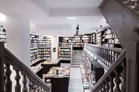 Vista general del interior de la librería con estanterías y escalera