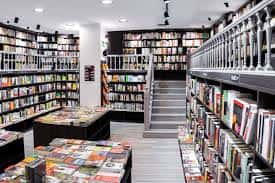 Interior de la librería mostrando los pasillos de libros y la escalera central