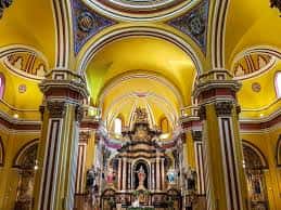 Interior del altar mayor con decoración dorada y bóvedas pintadas