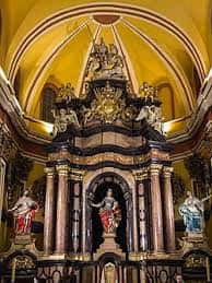 Detalle del retablo principal con esculturas y elementos ornamentales barrocos