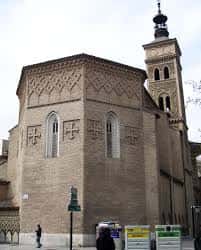 Vista exterior de la Iglesia de San Miguel de los Navarros en Zaragoza, mostrando su fachada de ladrillo y torre campanario