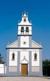Iglesia de Santa Marta con torre campanario y fachada blanca bajo cielo azul