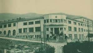 Fachada histórica del Colegio Loyola con arquitectura clásica y entorno montañoso al fondo