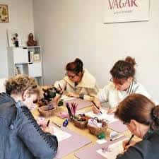 Grupo de participantes realizando talleres creativos en mesas de trabajo