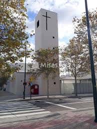 Vista exterior de la Parroquia de Jesús Maestro con su torre blanca y cruz en la parte superior