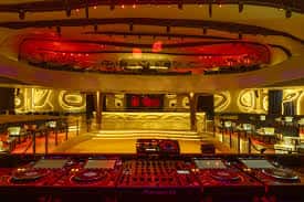 Escenario principal con luces rojas y consola de DJ