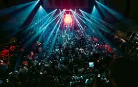 Concierto en el club con iluminación de focos y multitud