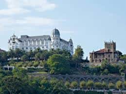 Panorámica del Eurostars Hotel Real desde una colina con vegetación y arquitectura histórica cercana