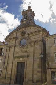 Fachada principal de la Iglesia de Santa María do Camiño con torre y cruz en la cúspide
