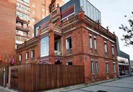Vista exterior de la Casa de la India con su fachada de ladrillo rojo y detalles arquitectónicos