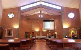 Interior de la Parroquia de San Lamberto con altar y bancos de madera