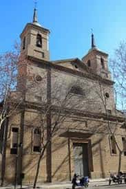Vista exterior frontal de la iglesia con sus dos torres y fachada de ladrillo