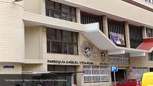Entrada lateral de la parroquia con letrero identificativo y marquesina moderna
