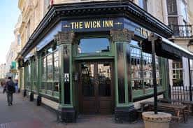 Fachada exterior del The Wick Inn en Brighton, mostrando su arquitectura victoriana y letrero distintivo