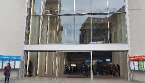 Entrada principal de la estación con grandes ventanales y reflejos arquitectónicos