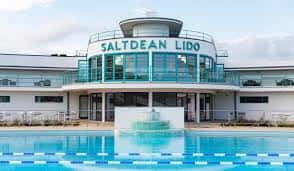 Vista frontal del Saltdean Lido con piscina azul y letrero art deco