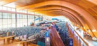 Interior del Pabellón de la Navegación con techo curvo de madera y multitud de asistentes en evento