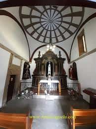 Interior de la capilla con vista al altar y cúpula decorada