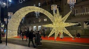 Arco de luces y estrella decorativa en plaza pública durante la Navidad en Vigo