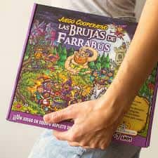 Persona sosteniendo el juego cooperativo 'Las Brujas de Farrabus' de Dendamundi