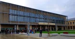 Vista exterior de la Biblioteca Pública Nodal de Ourense con personas en el patio