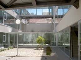 Patio interior con estructura de cristal y escaleras modernas