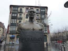 Detalle del busto de Alexander Fleming en la plaza, con fachadas históricas de Bilbao detrás